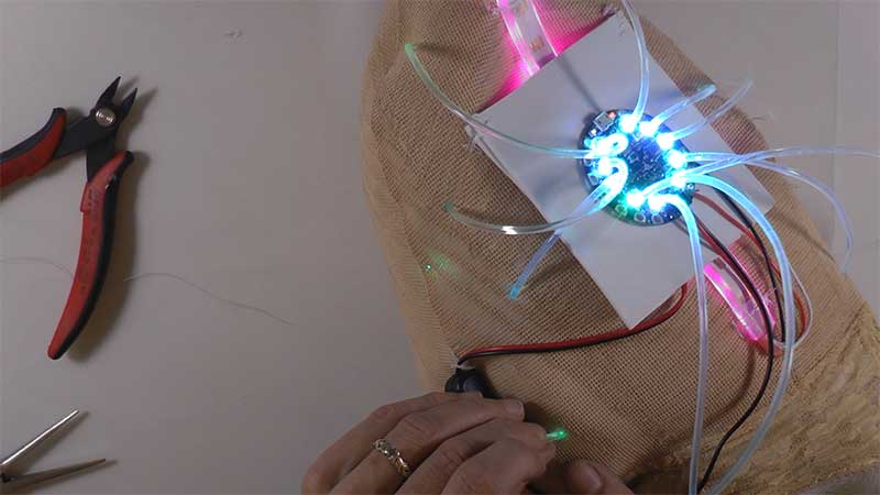 Clip holes in fabric & slip light pipe strands through