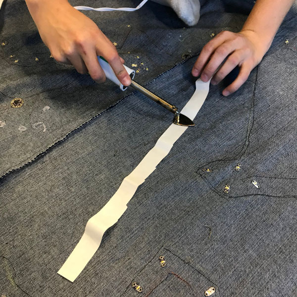 Lay garment flat and iron on adhesive around circuit