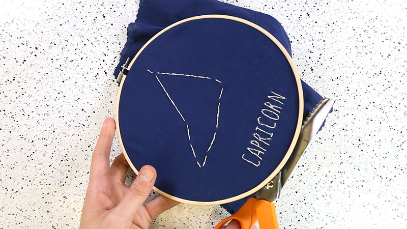 cut away the excess fabric around the hoop