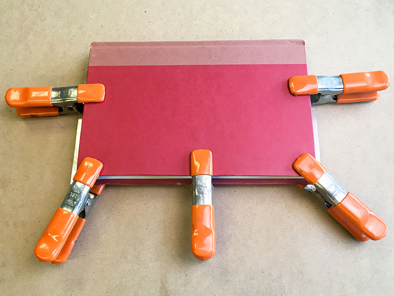 Use a set of clamps to hold book closed during drying